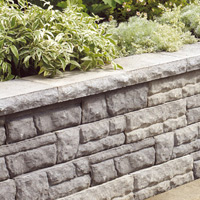 Low wall with natural-looking stone, topped with cap blocks