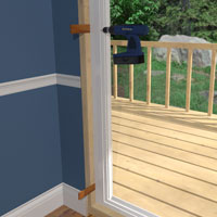 Screw the door frame to the jambs, through the shims. 