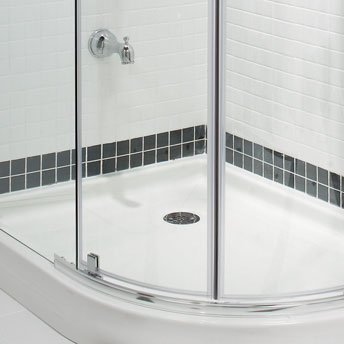 Drain de douche dans la salle de bain. Douche en céramique et panneaux vitrés arrondis
