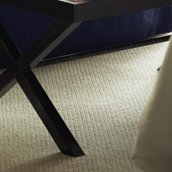 Moquette ou tapis texturé qui couvre toute la surface du salon