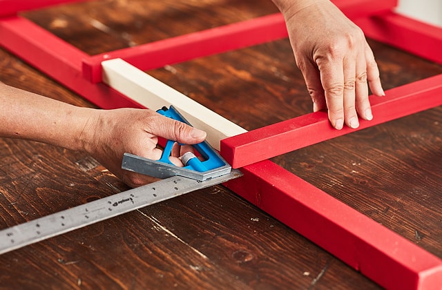 Person measuring wood with a sliding square