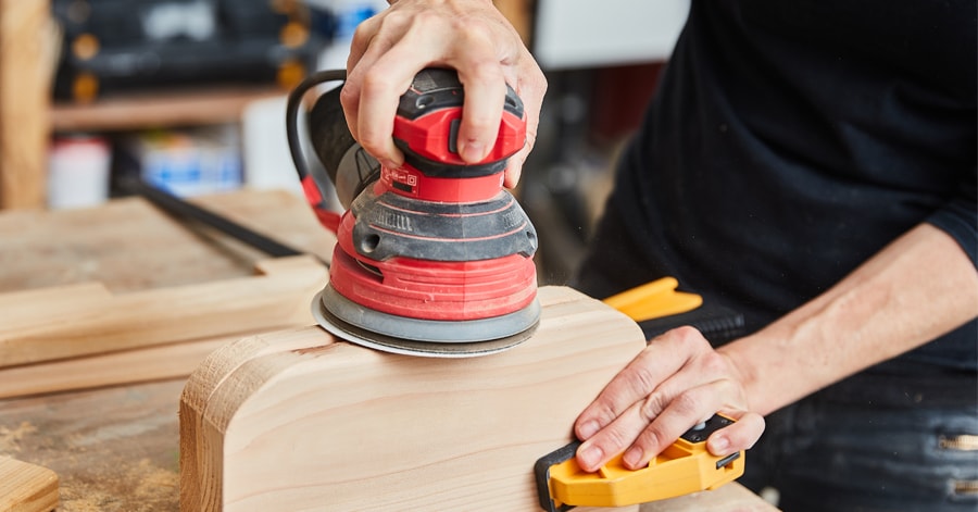 Person sanding wood using a sander