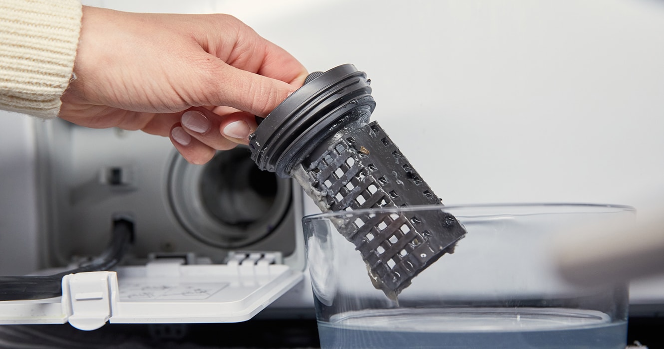 Person rinsing a washer filter