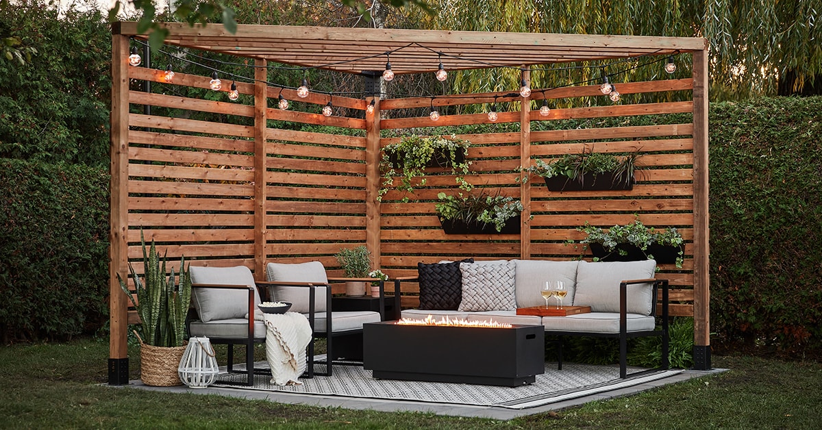 Corner pergola with string lights and a patio set