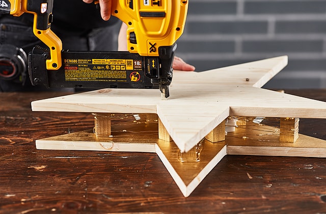 Person assembling a wooden star 