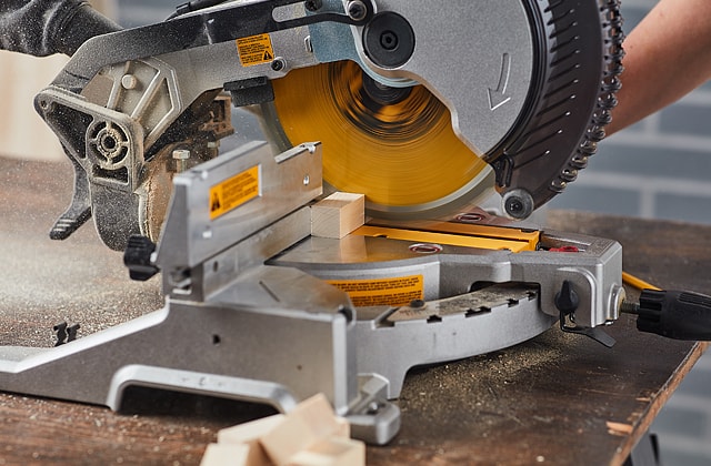 Person cutting a wooden stick
