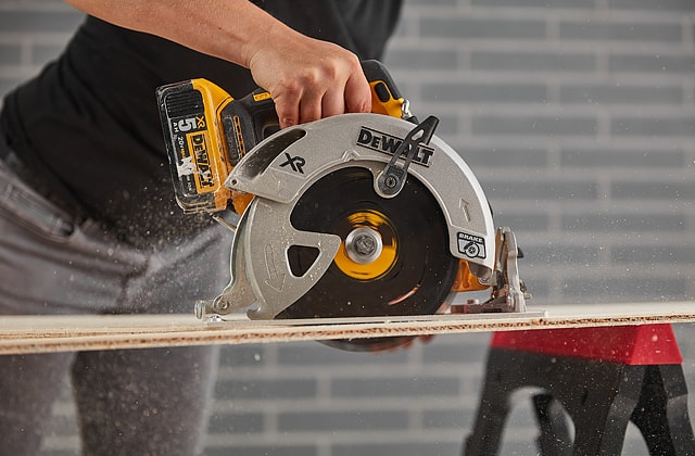 Person cutting plywood with a circular saw