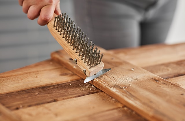 Person damaging wood with a scraper