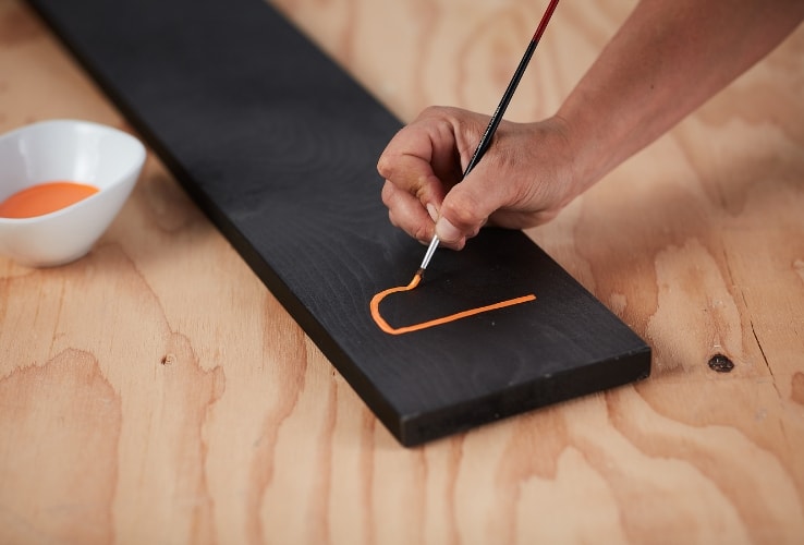 Personne peinturant une planche de bois Personne peinturant une planche de bois