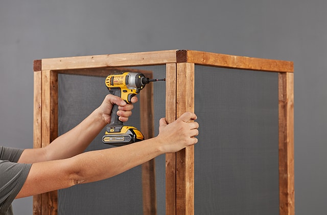Person joining wooden frames using screws