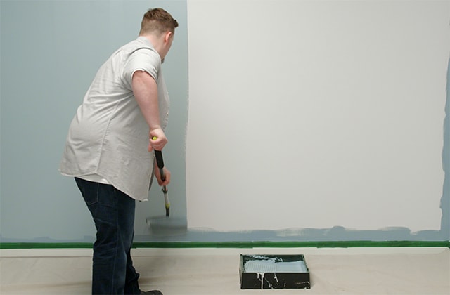 Man painting a wall blue