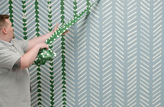 Man removing tape from a wall