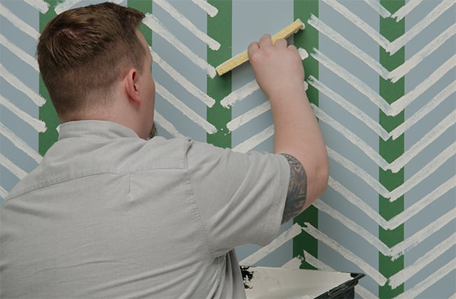 Man creating a herringbone pattern on a wall