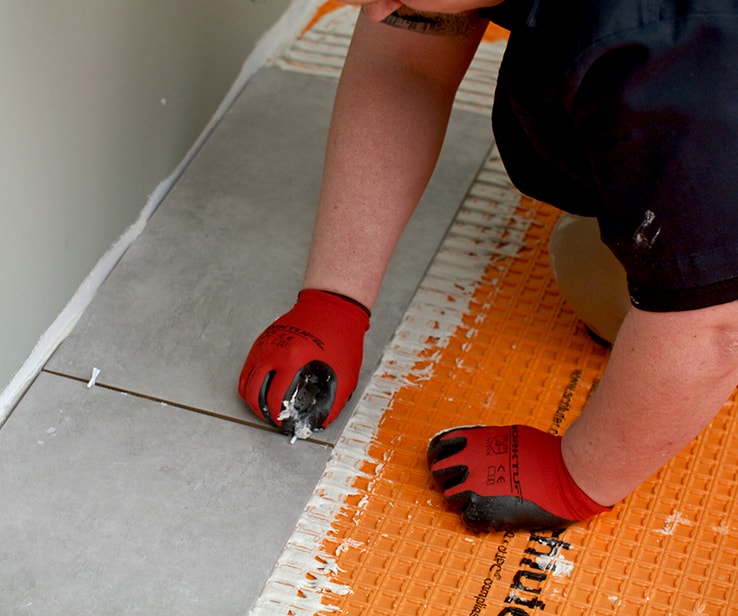 Person adding spacers between tiles
