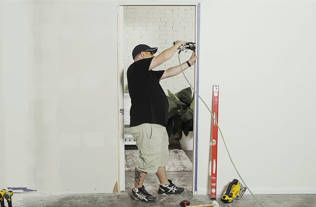 Person installing a lock on a pocket door