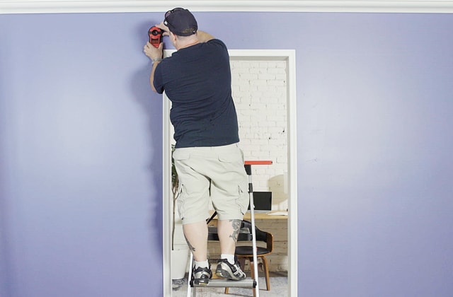 Person using a stud finder on a wall