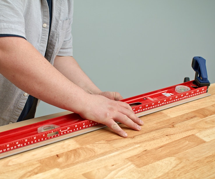 Person snapping a plank along a workbench