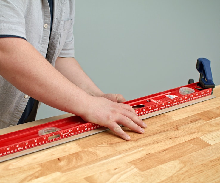 Person snapping a plank along a workbench