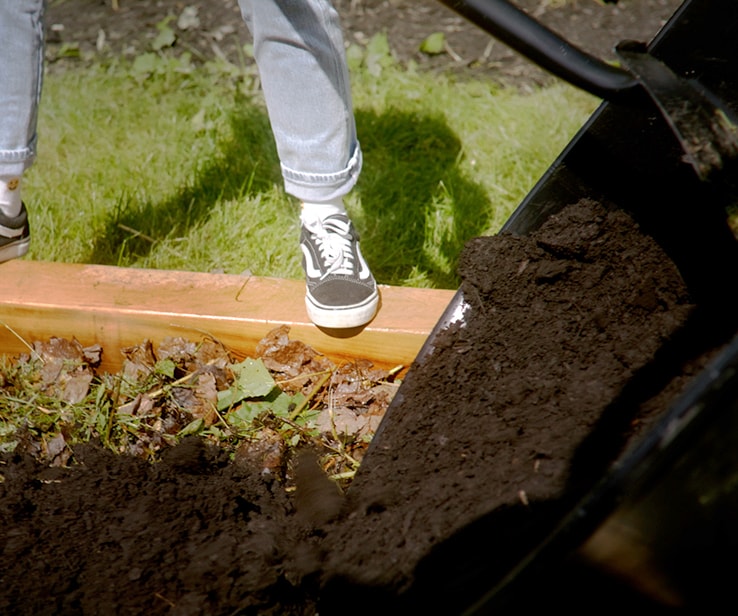 Personne étendant du compost au jardin Personne étendant du compost au jardin