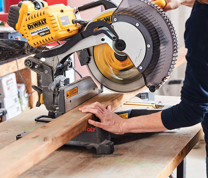 Woman using a mitre saw Woman using a mitre saw