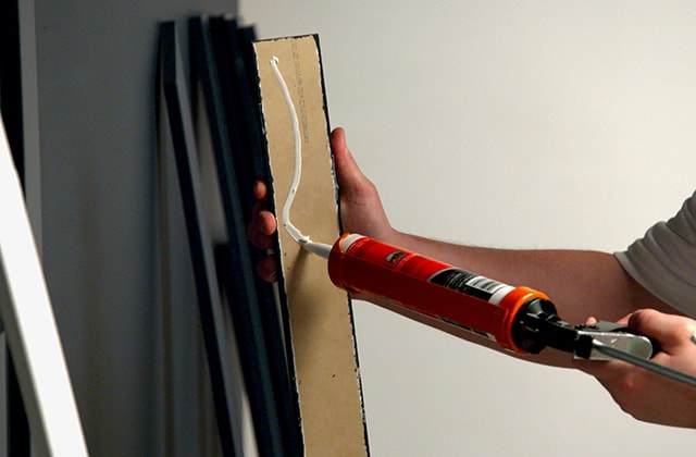 Man applying adhesive onto a moulding