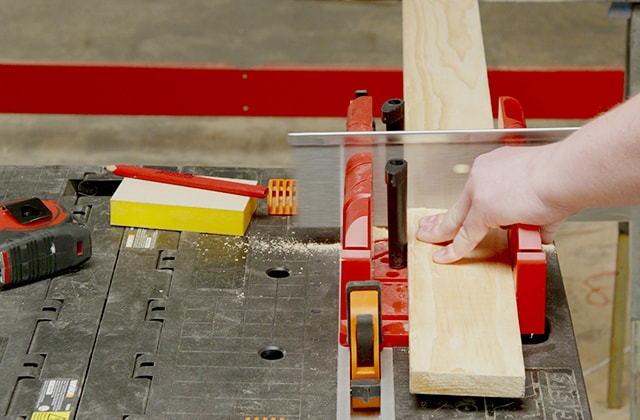 Person cutting a piece of wood