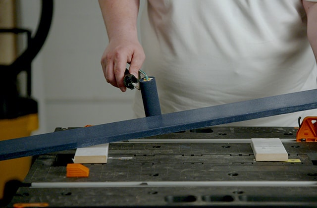 Man painting a moulding blue