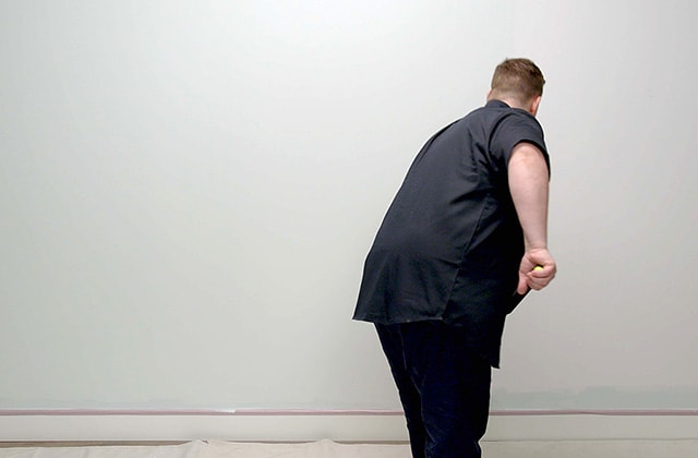 Person painting a wall