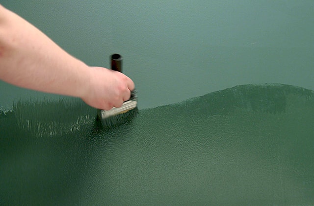 Person finalizing a forest-inspired mural