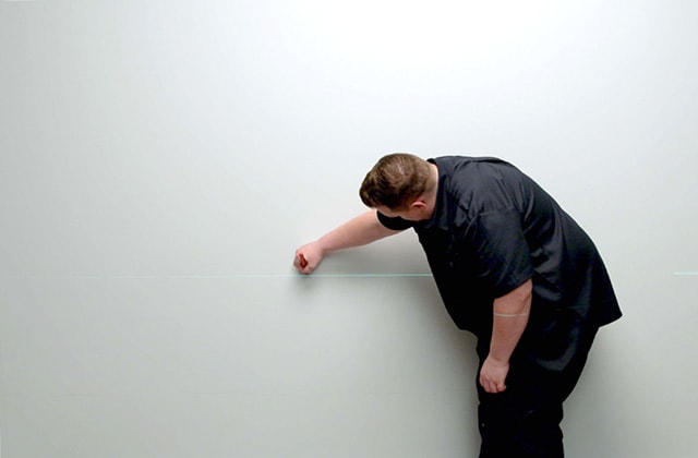 Person using a laser level to trace a line