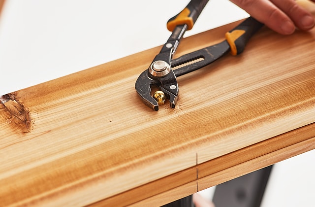 Person tightening a brass bold