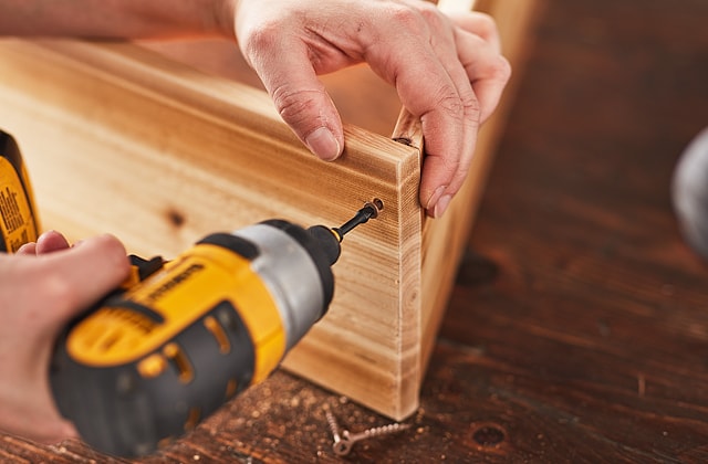 Person screwing two pieces of wood together