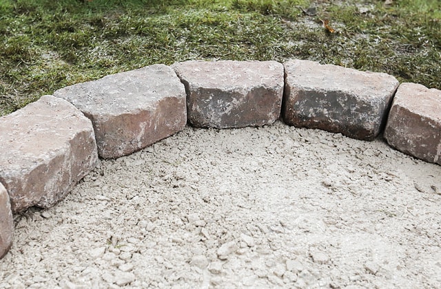 Place the first row of cinder blocks for the firepit