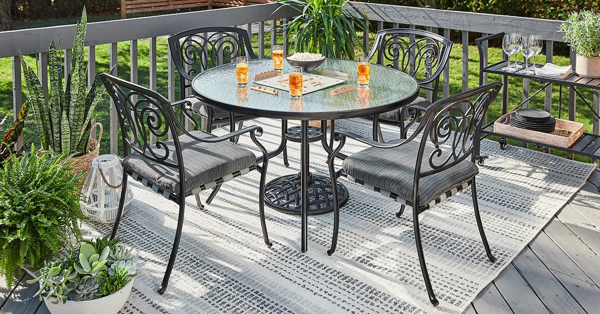 Deck with black metal patio furniture and a grey carpet