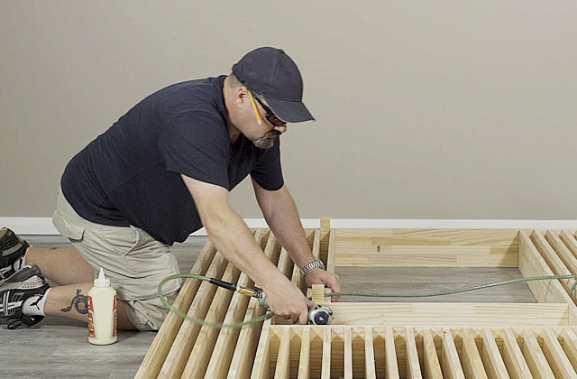 Person assembling a wooden structure on the floor