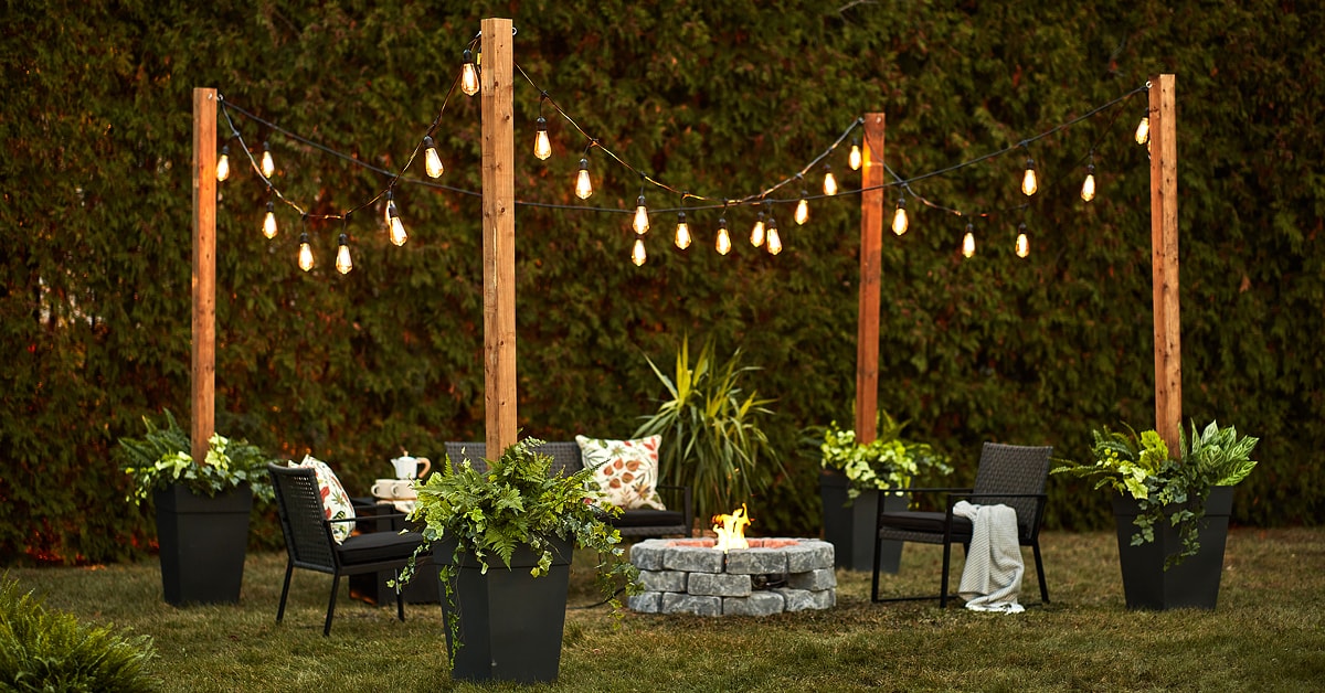 Outdoor fireplace surrounded by string light poles