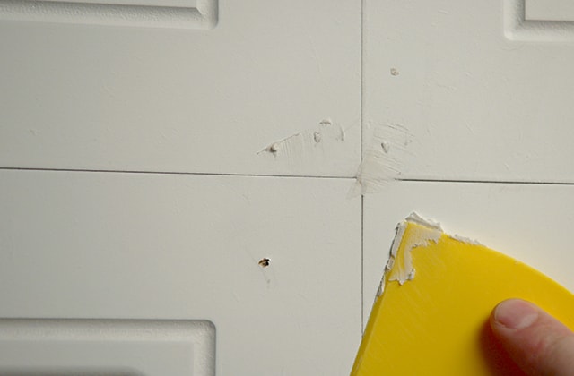 Person filling nail holes