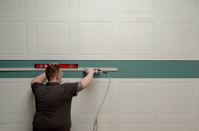 Person using a level to install a chair rail