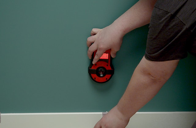 Person marking stud locations on a floor