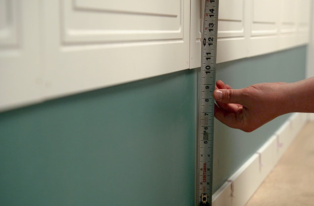 Person measuring a wall