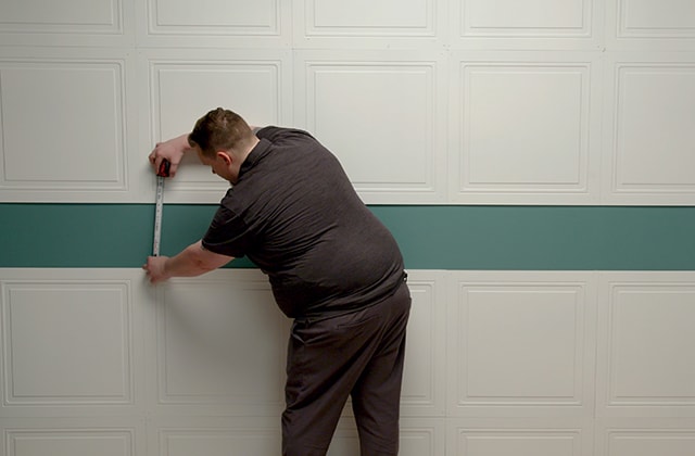 Person measuring a wall