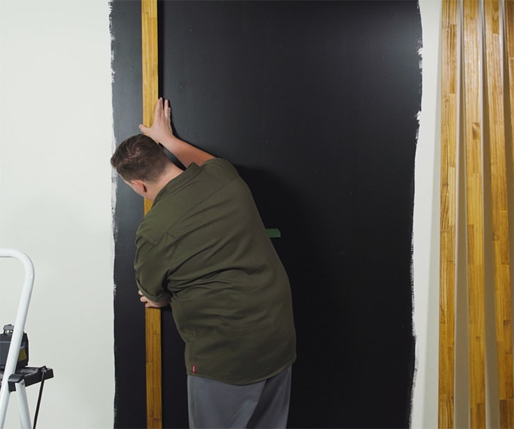 Man installing wood slats on a wall