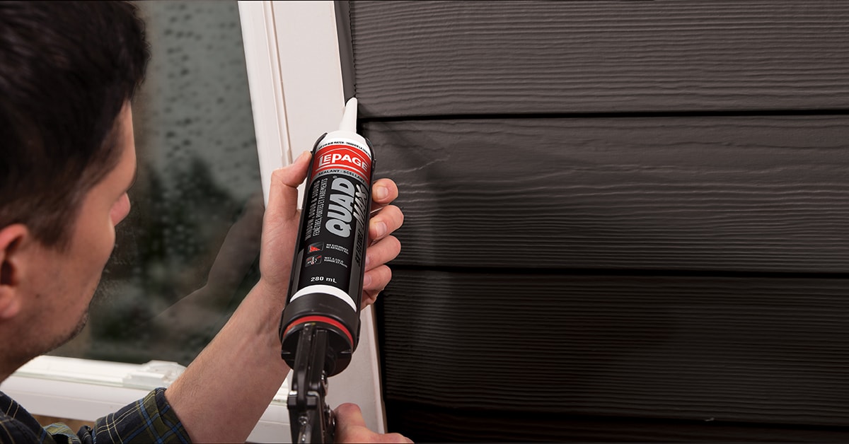 Women applying caulk to an exterior door Women applying caulk to an exterior door