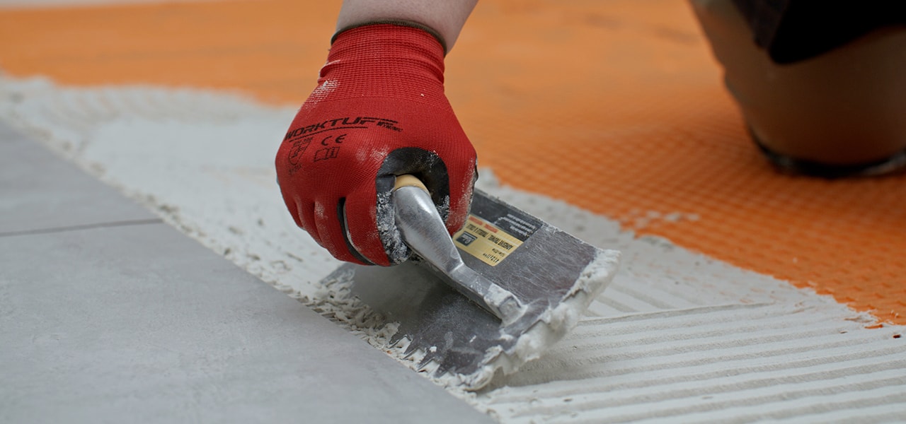 Homme posant un plancher de céramique Homme posant un plancher de céramique
