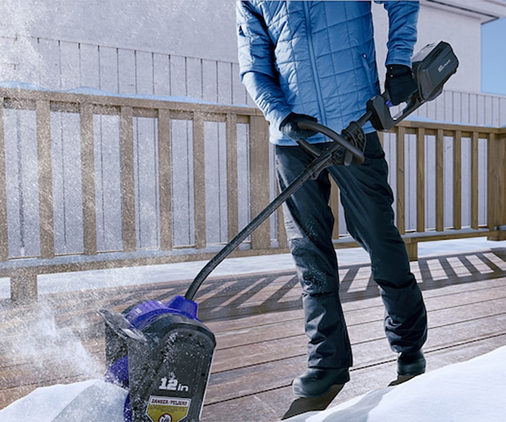 Homme utilisant une pelle à neige électrique Homme utilisant une pelle à neige électrique