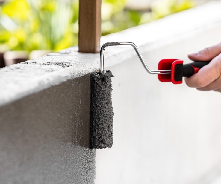 Personne peinturant une surface en béton Personne peinturant une surface en béton