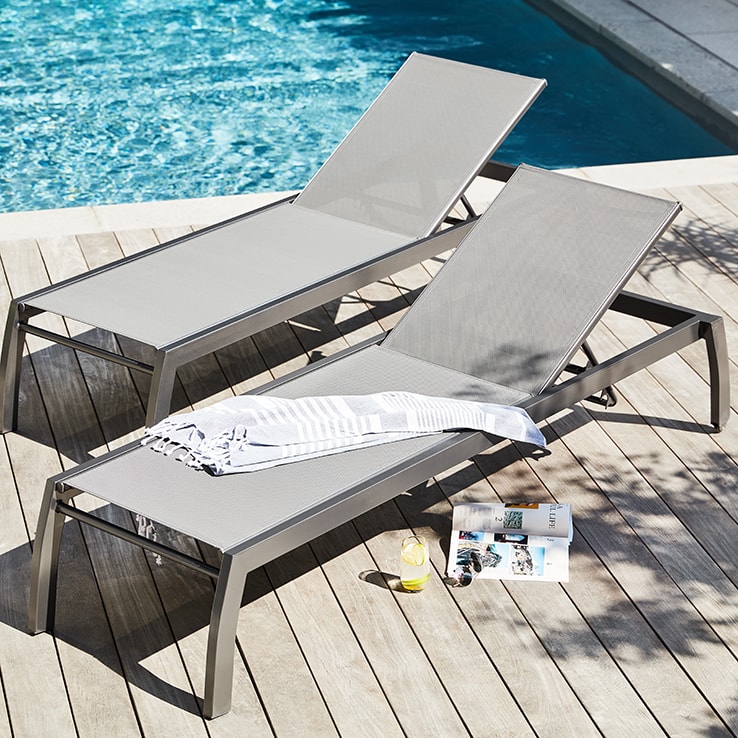 Two lounge chairs by a pool