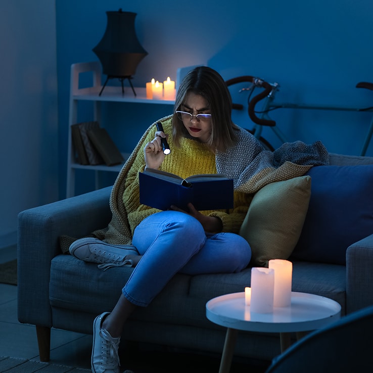 Jeune femme lisant pendant une panne de courant Jeune femme lisant pendant une panne de courant