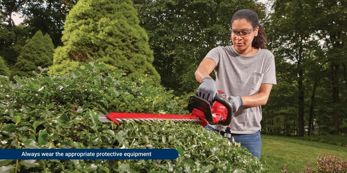 Person using a trimmer with safety equipment