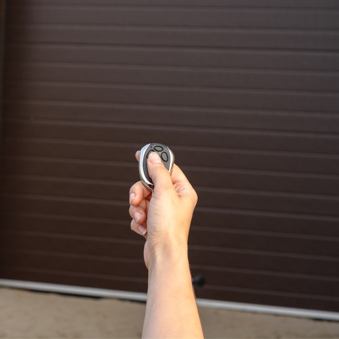 Person opening a garage door with a remote